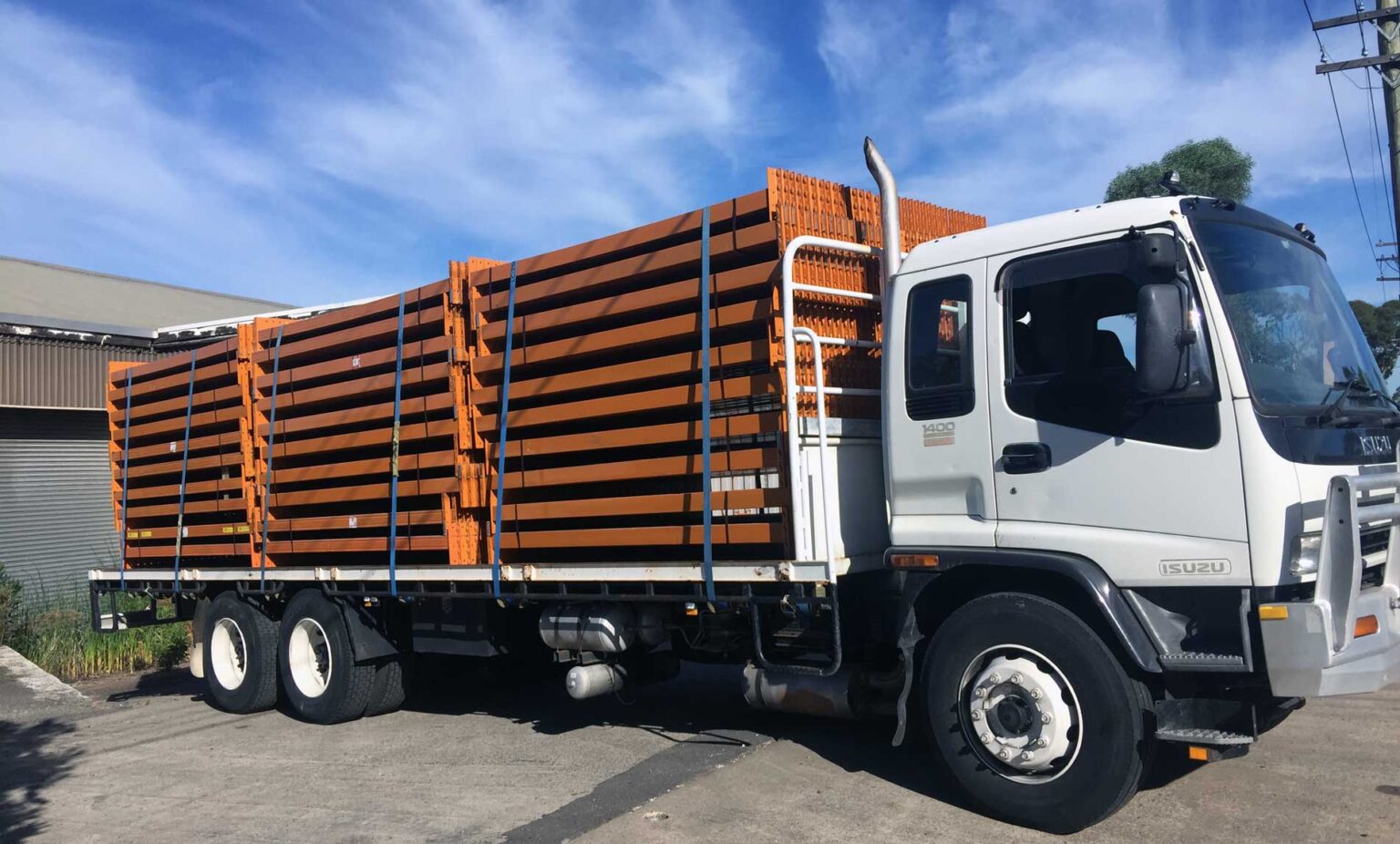 Flatbed truck loaded with orange structural beams
