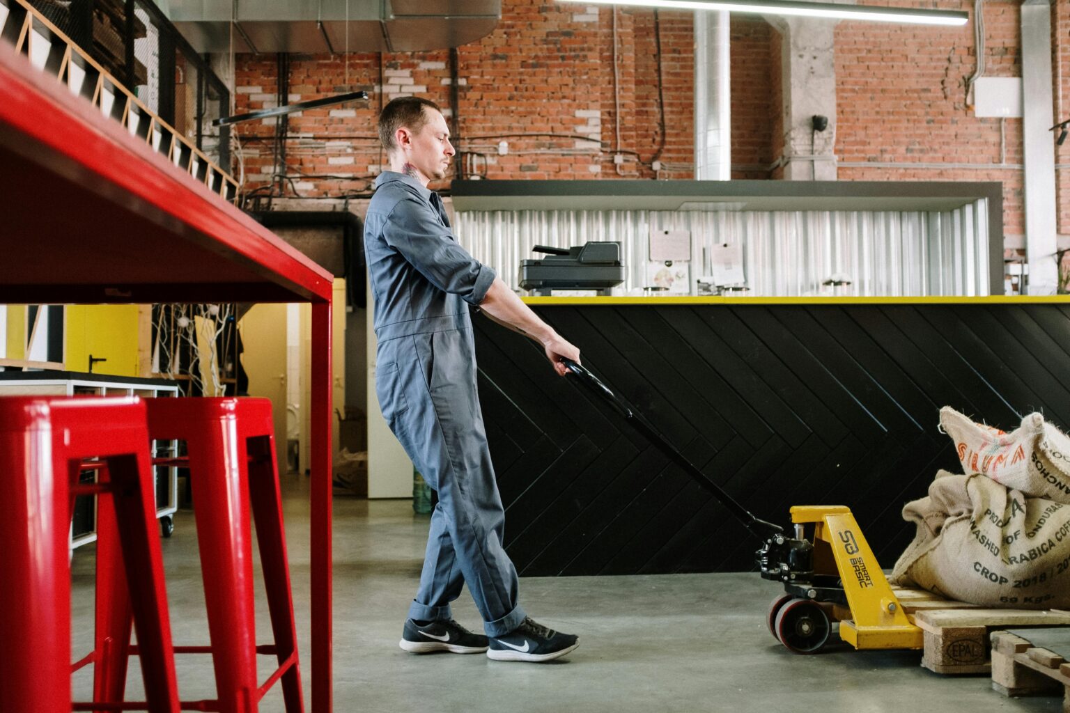 Worker operating a pallet jack in a warehouse